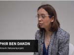 Saphir Ben Dakon conducts the interview. She sits away from the camera and is focussed. Her name and role are shown at the bottom of the image.