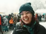 Auf dem Bild ist Saphir Ben Dakon zu sehen. Sie steht draussen im Schnee und lacht in die Kamera.
