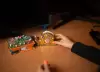 Auf dem Arbeitstisch stehen ein Klebeband und ein Notizenhalter. Sie sind mit Glitzer und Steinen verziert und wurden für Saphir an einem Workshop für Kinder erstellt. 