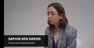 Saphir Ben Dakon conducts the interview. She sits away from the camera and is focussed. Her name and role are shown at the bottom of the image.