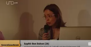 Saphir Ben Dakon spricht am Generationentandem. Auf dem Bild ist auch ein Laptop. Unten sind ihr Name, ihr Alter 28 und ihre Vorstandsmitgliedschaften eingeblendet.
